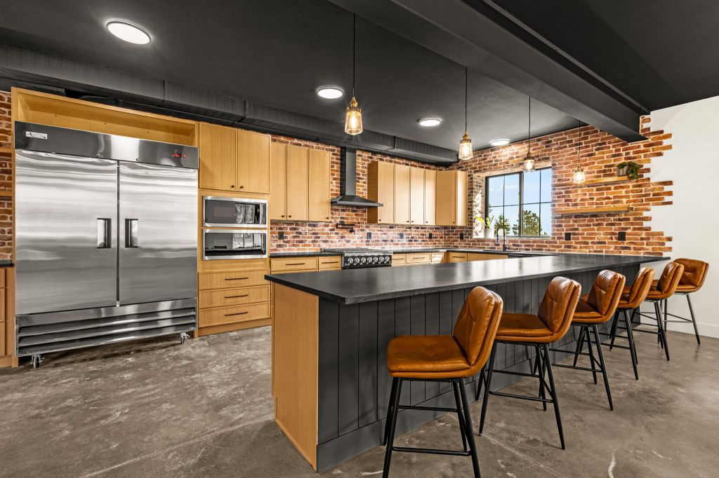 Kitchen with an island and bar. With an industrial size fridge in the modern workshop. 