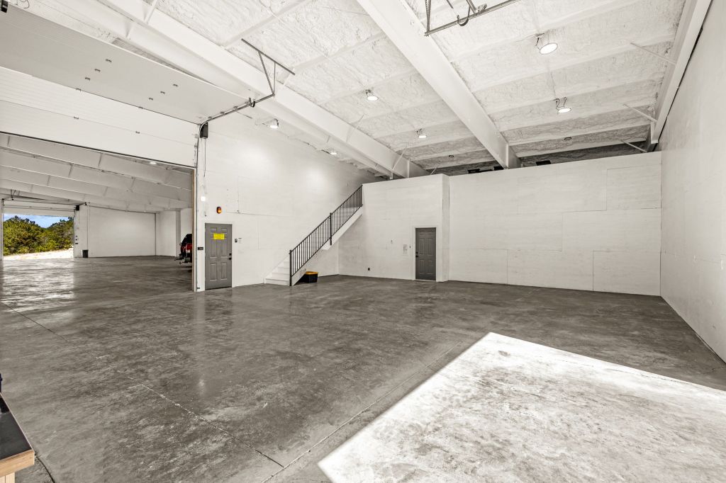 Garage with a stair case that leads to the Warhouse of the Modern Workshop.